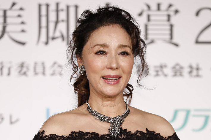 女優の高島礼子さんが、華やかな黒いオフショルダードレスを着て、トロフィーを持っています。