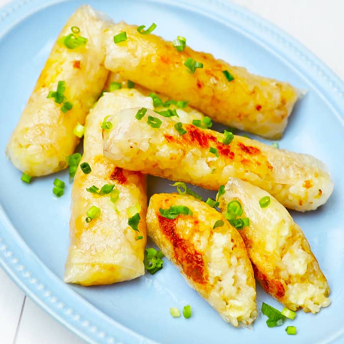 お皿に盛られた焼き春巻きが並んでいる。細かく刻まれたネギが散りばめられている。