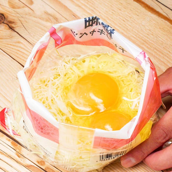 袋に入った卵2個と千切りキャベツが見える。