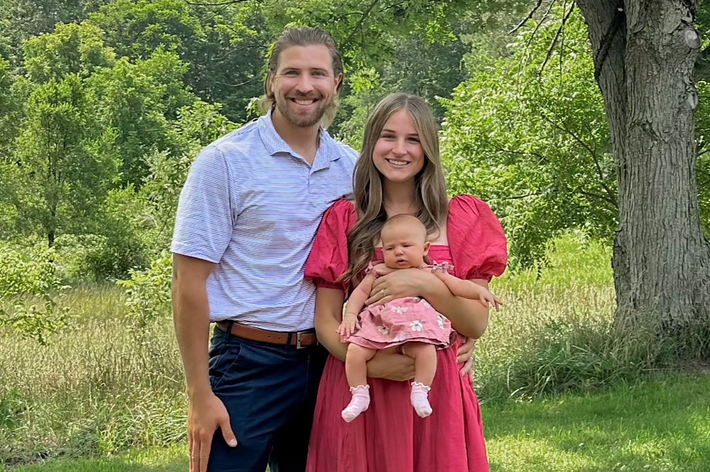 男性、女性、赤ちゃんが森の中で家族写真を撮影。上部に「our invisible string」というテキスト。