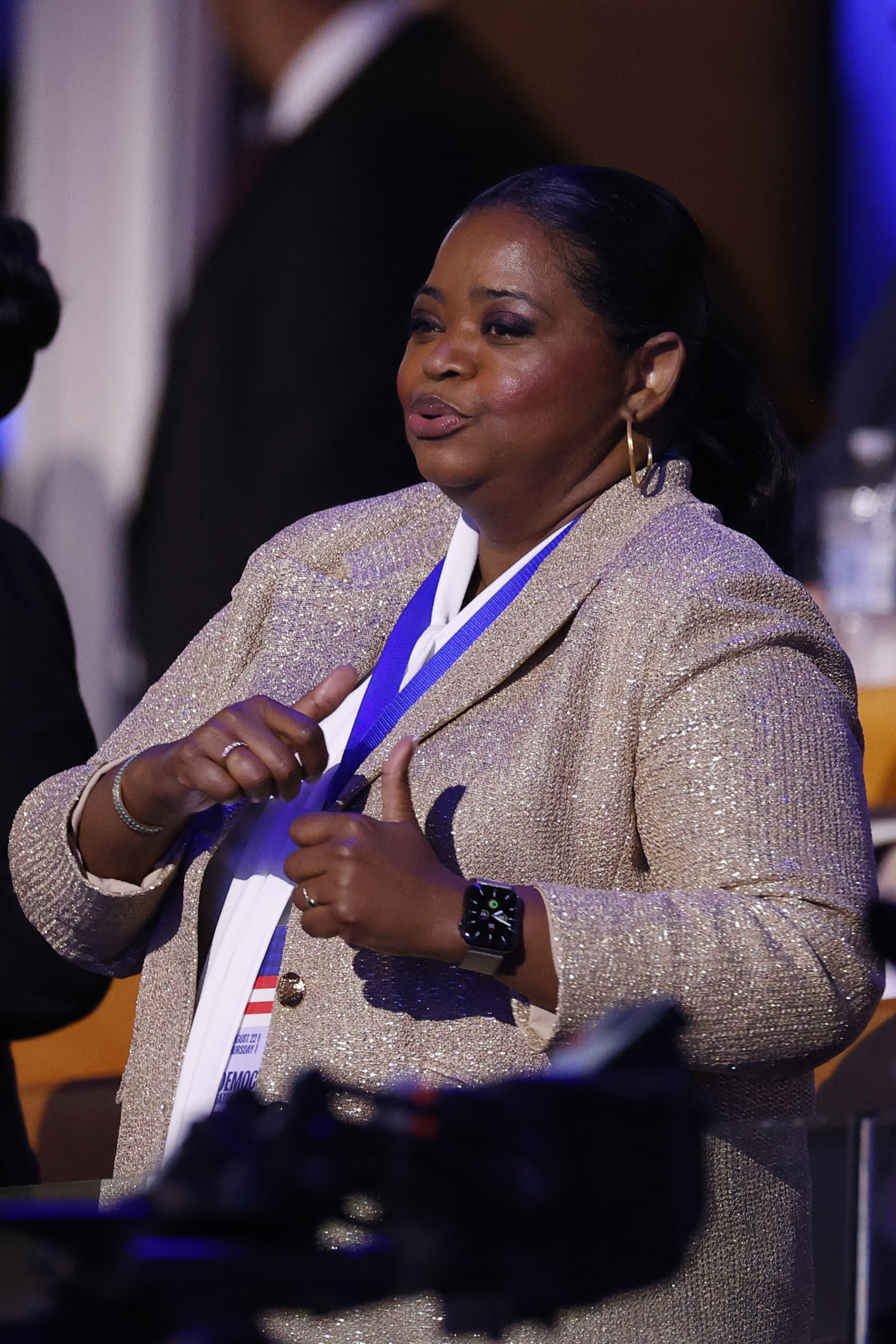 Octavia Spencer gives two thumbs up while wearing a sparkly blazer at an event
