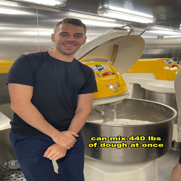 Me standing by a large dough mixer in a commercial kitchen, the mixer can mix 440 lbs of dough at once