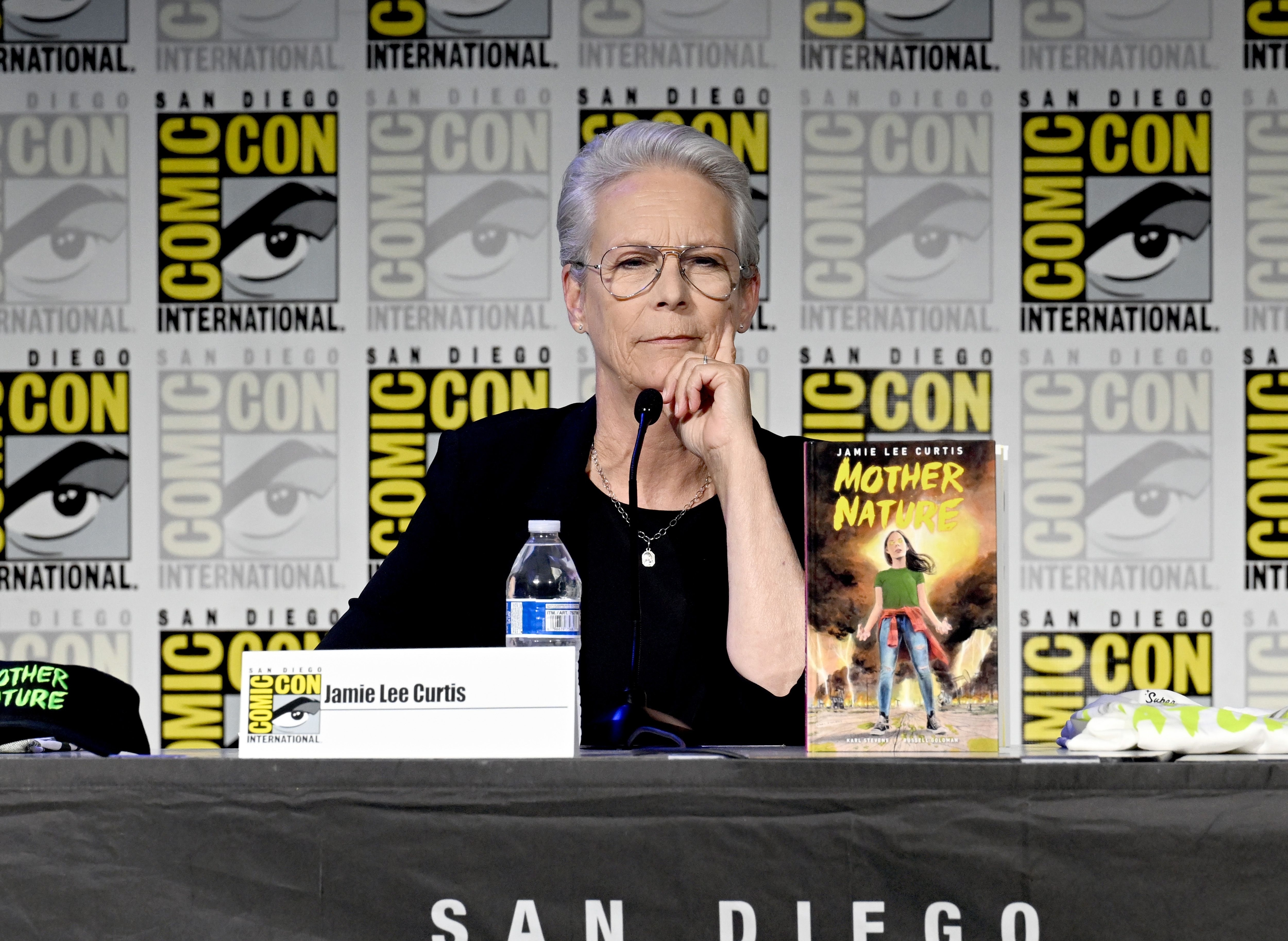 Jamie Lee Curtis at San Diego Comic-Con, seated at a panel table with a "Mother Nature" book