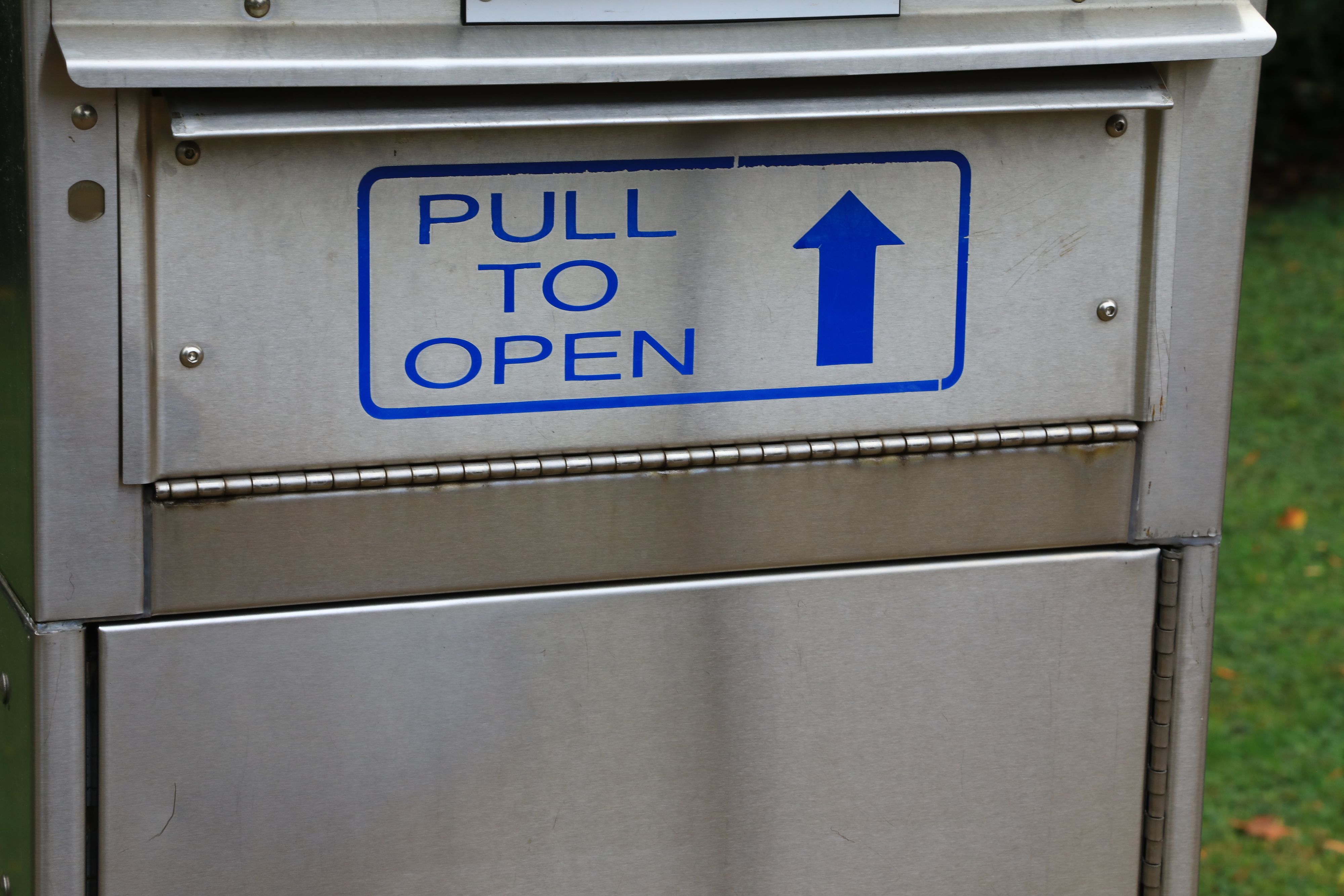 Metallic box with a sign that reads &quot;PULL TO OPEN&quot; and features an upward-pointing arrow