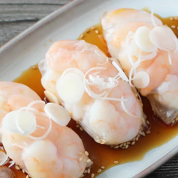 お皿に盛り付けられた3つのエビぎょうざ、上にはスライスされたネギが載せられています。