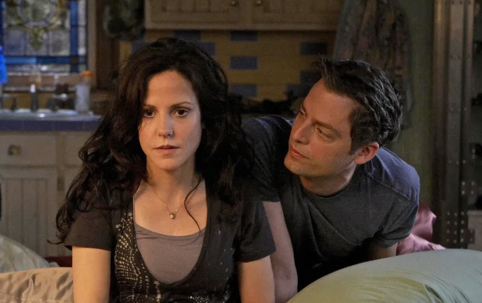 Mary-Louise Parker and Justin Kirk in a scene from a TV show set in a kitchen, with Parker looking forward and Kirk looking at her