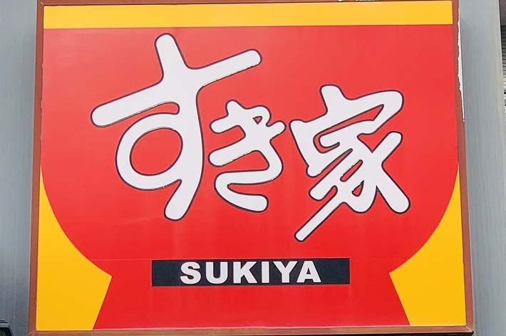 赤い背景に「すき家」の大きな看板が見えており、その下には「SUKIYA」と書かれています。