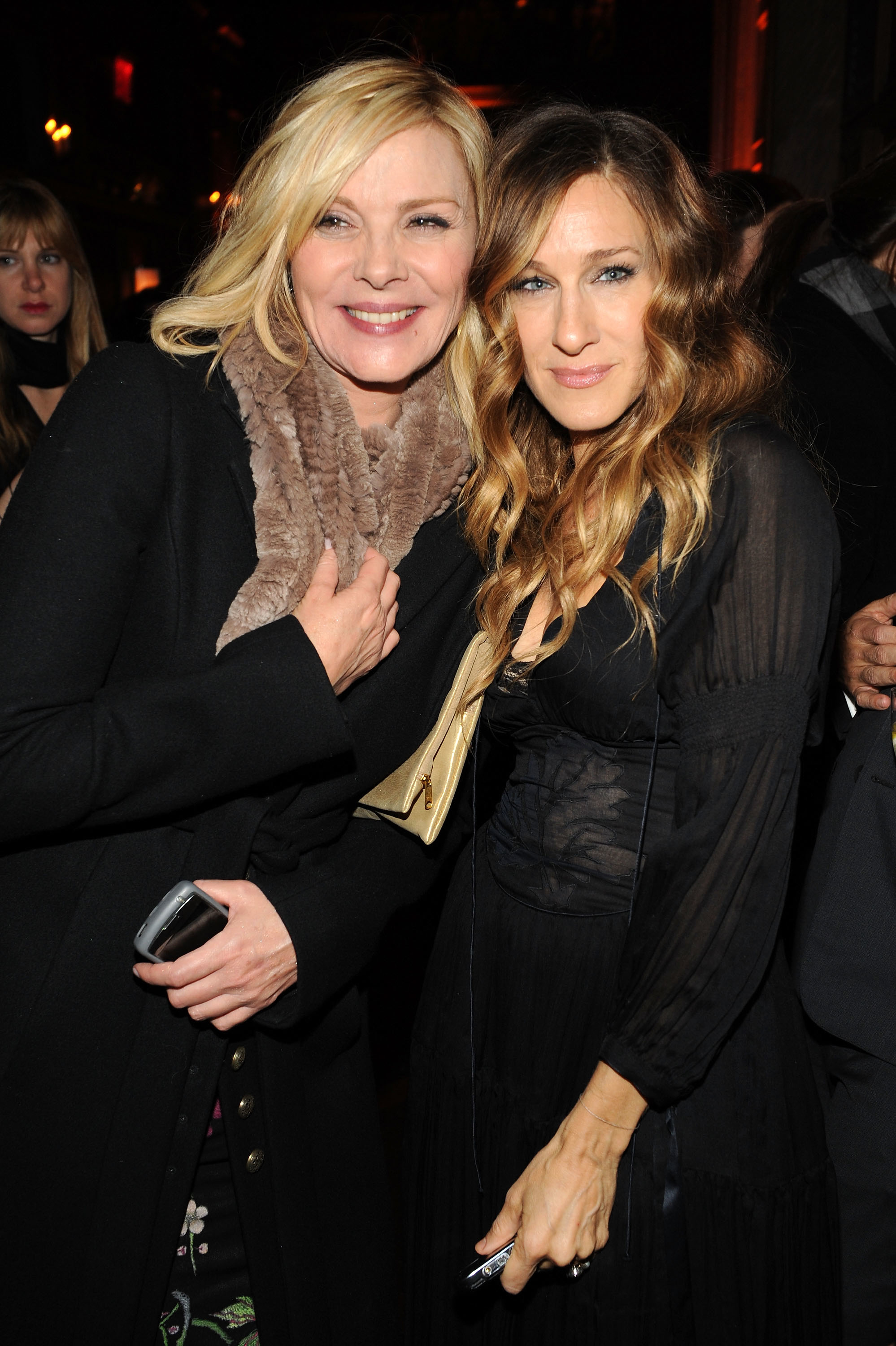 Kim Cattrall and Sarah Jessica Parker smile together at an event.