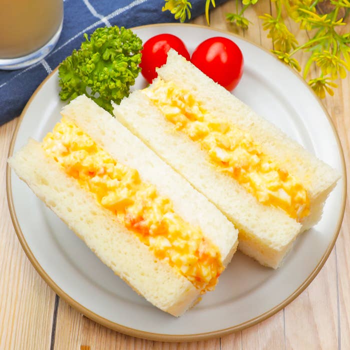 おしゃれなプレートに盛り付けられた卵サンドイッチとミニトマト。