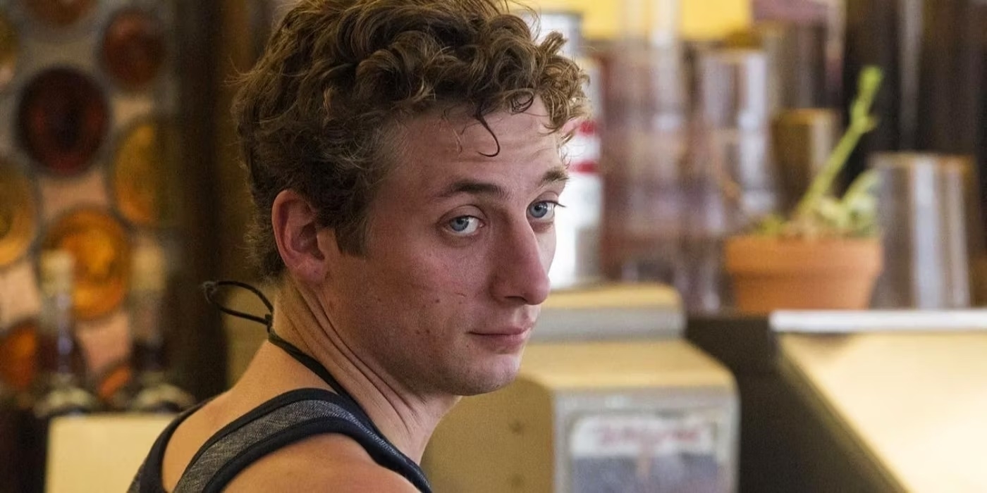 Jeremy Allen White at a diner counter, wearing a tank top, with a focused expression