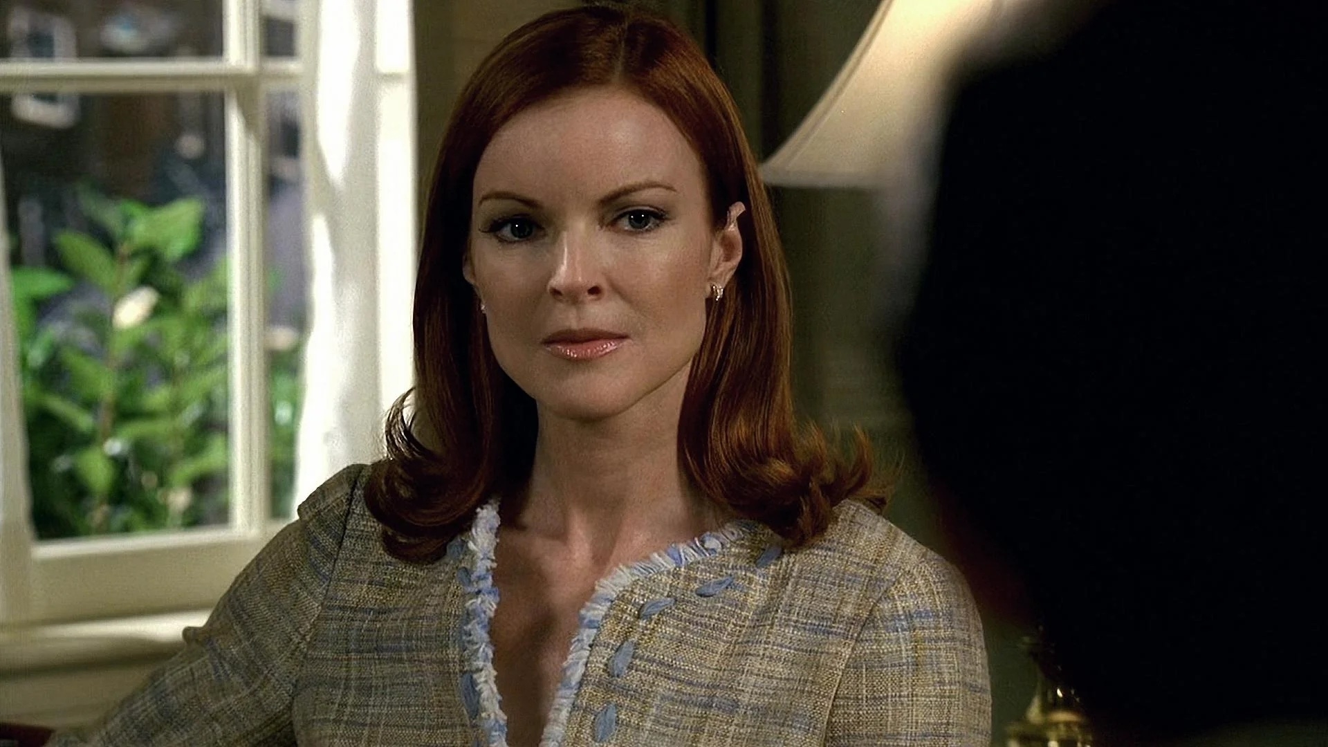 Marcia Cross as Bree Van de Kamp, dressed in a tailored blazer, seated indoors in a scene from "Desperate Housewives"