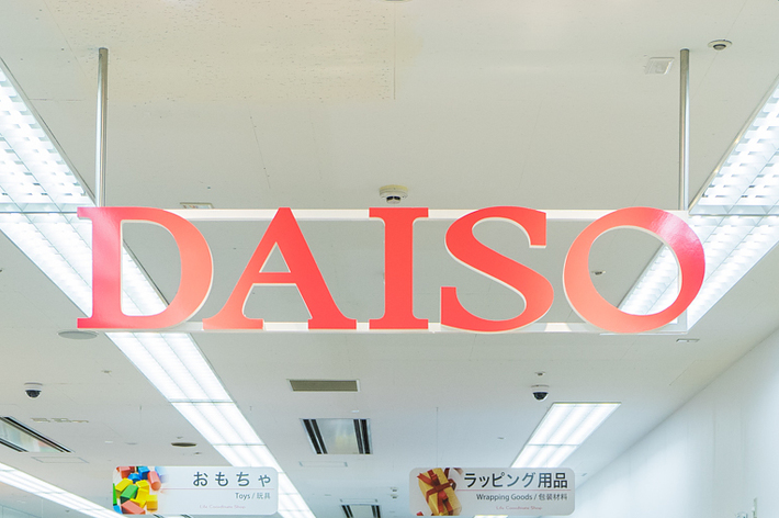 大創(DAISO)店舗内のハロウィンコーナー。様々なハロウィン関連商品が棚に並んでいる。買い物客が商品を見ている。