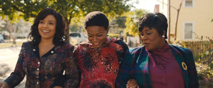 Sanaa Lathan, Aunjanue Ellis, Uzo Aduba walk together outdoors. They are dressed in stylish, patterned outfits and appear to be in a cheerful mood in a scene from the film