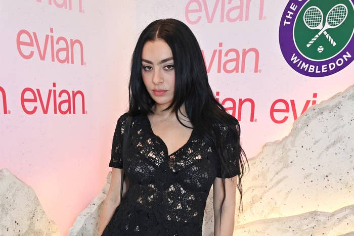 Charli XCX poses in a lace dress at an Evian event during Wimbledon