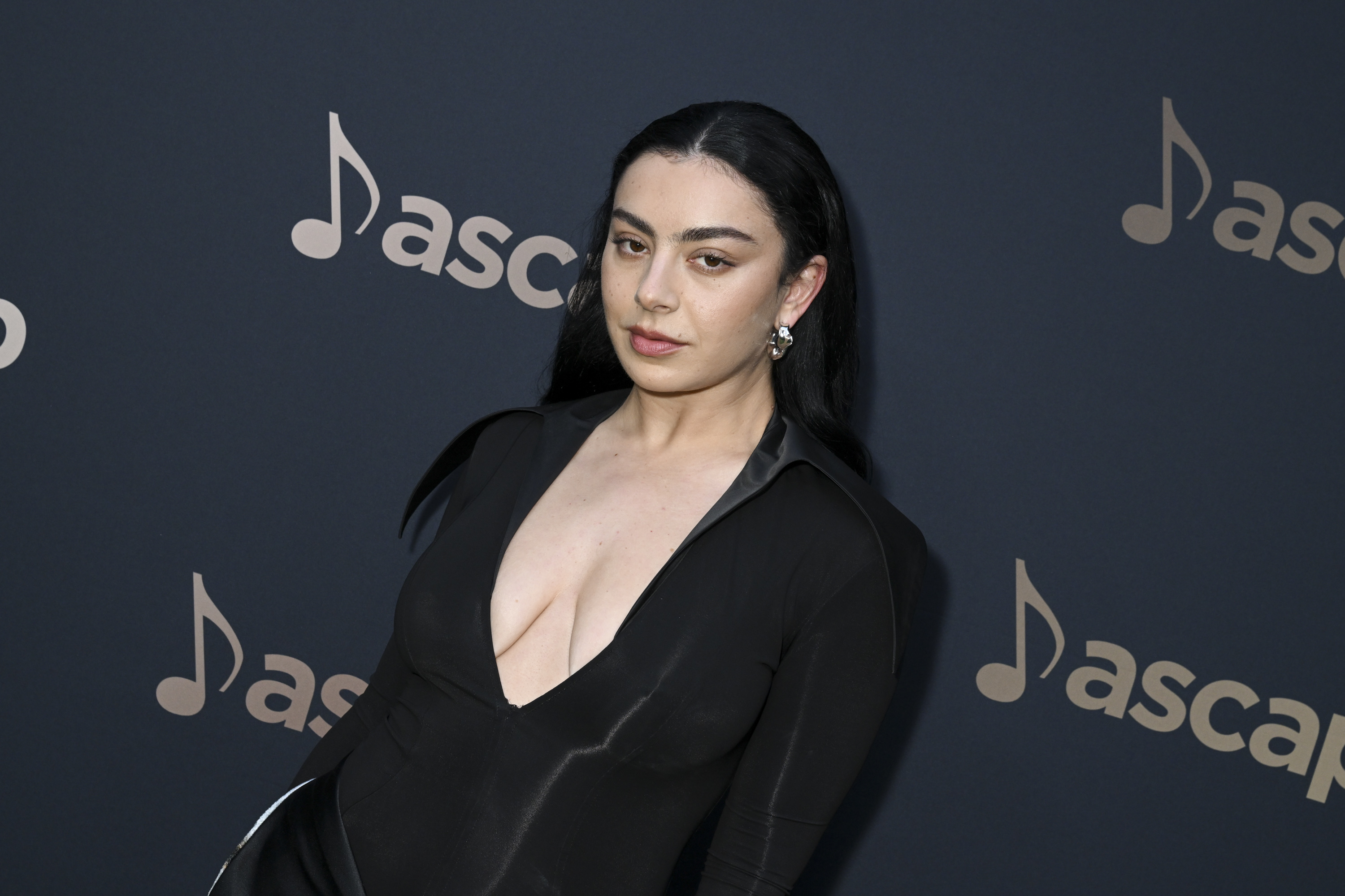 Charli XCX, on the red carpet at the ASCAP event, wearing a deep V-neck, long-sleeve gown