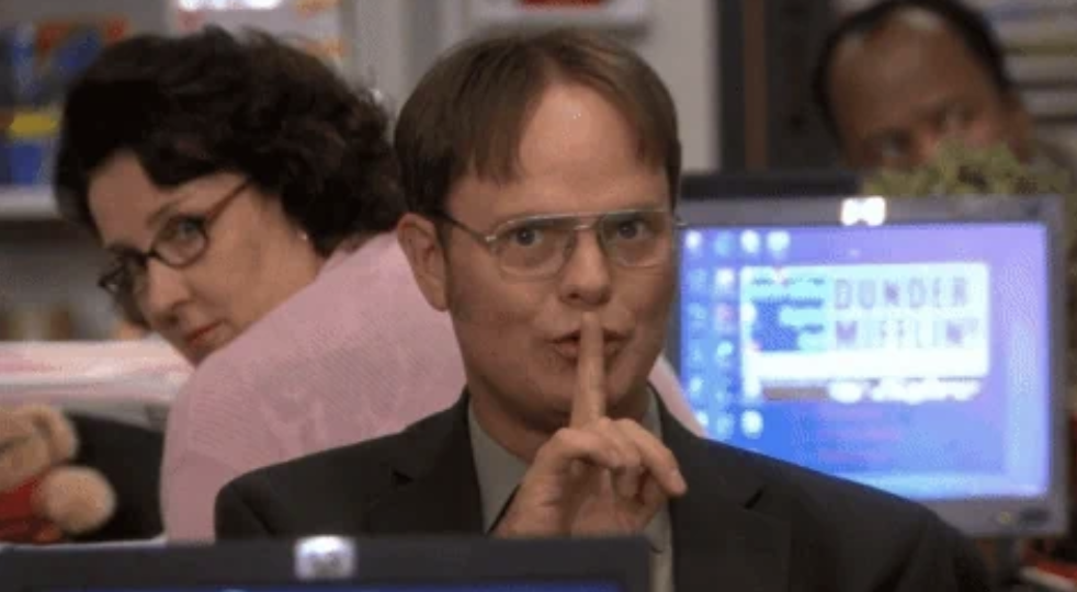 Dwight Schrute holding his finger to his lips in a &quot;shh&quot; gesture