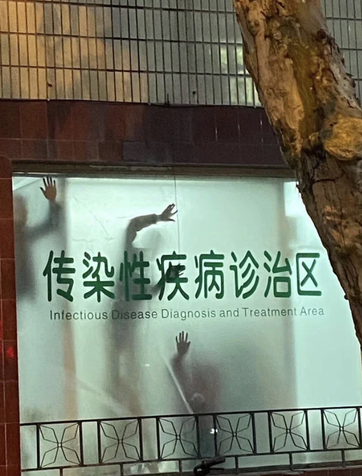 Silhouetted figures behind a foggy window of the “Infectious Disease Diagnosis and Treatment Area” as seen from outside the building