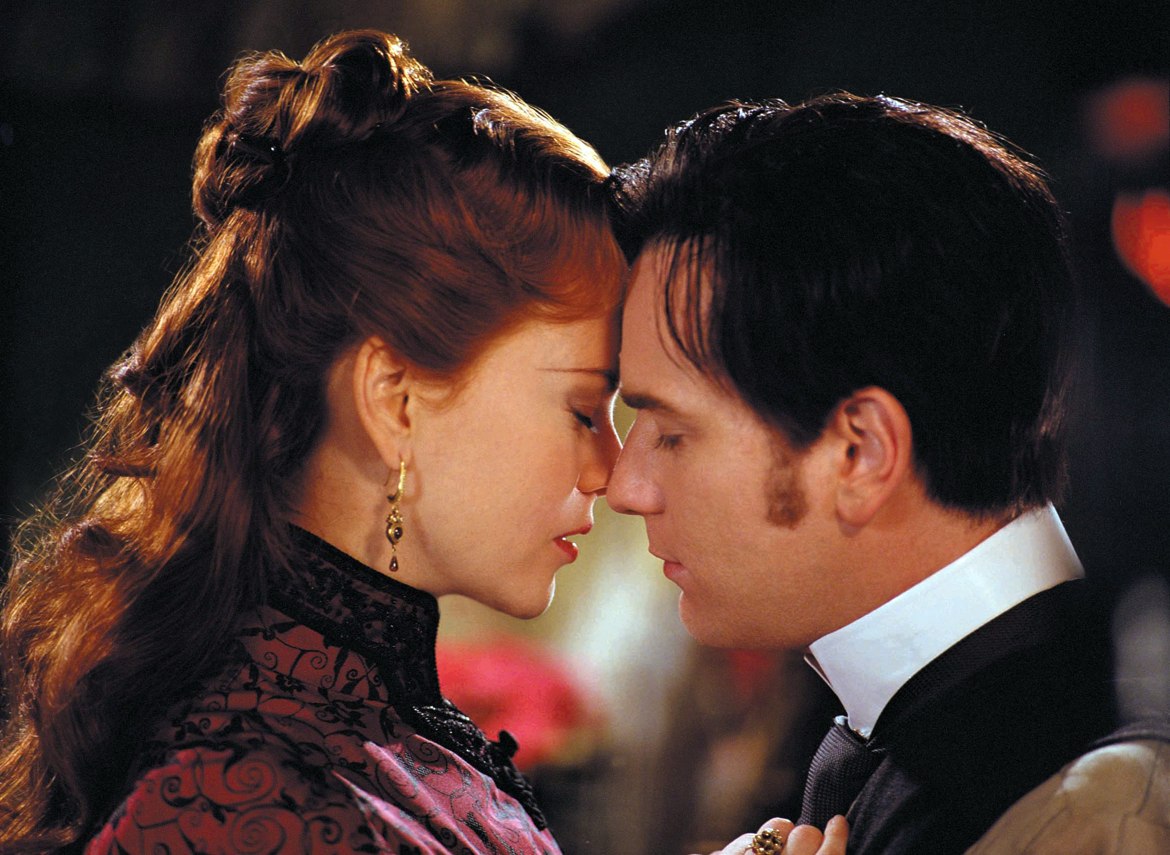 Nicole Kidman and Ewan McGregor in a close, intimate pose, facing each other with their foreheads touching, from the movie "Moulin Rouge!"