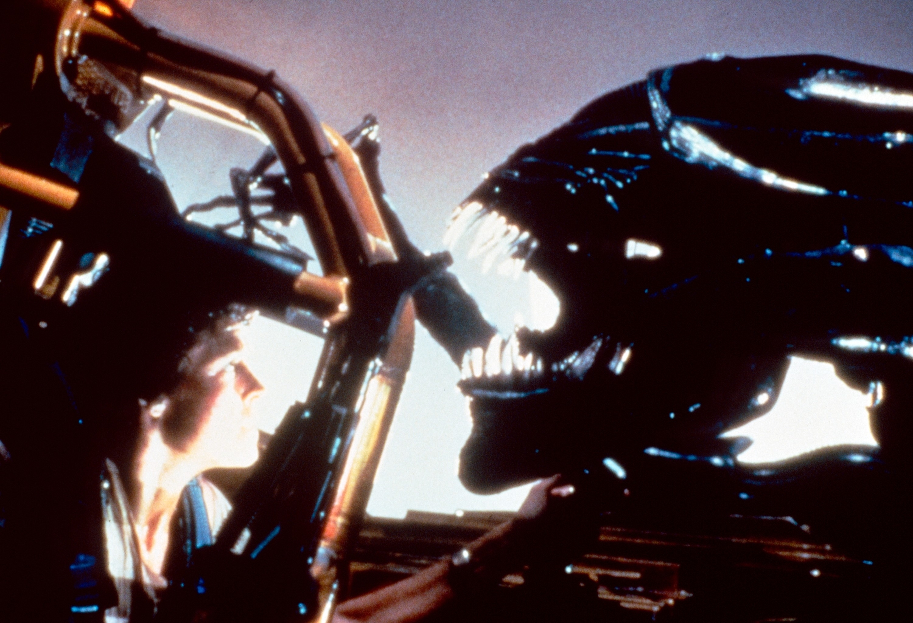Sigourney Weaver, as Ellen Ripley, faces a Xenomorph in a tense scene from the movie "Aliens."