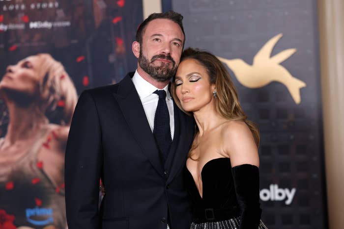 Ben Affleck in a suit and tie with Jennifer Lopez in a strapless gown, posing on a red carpet