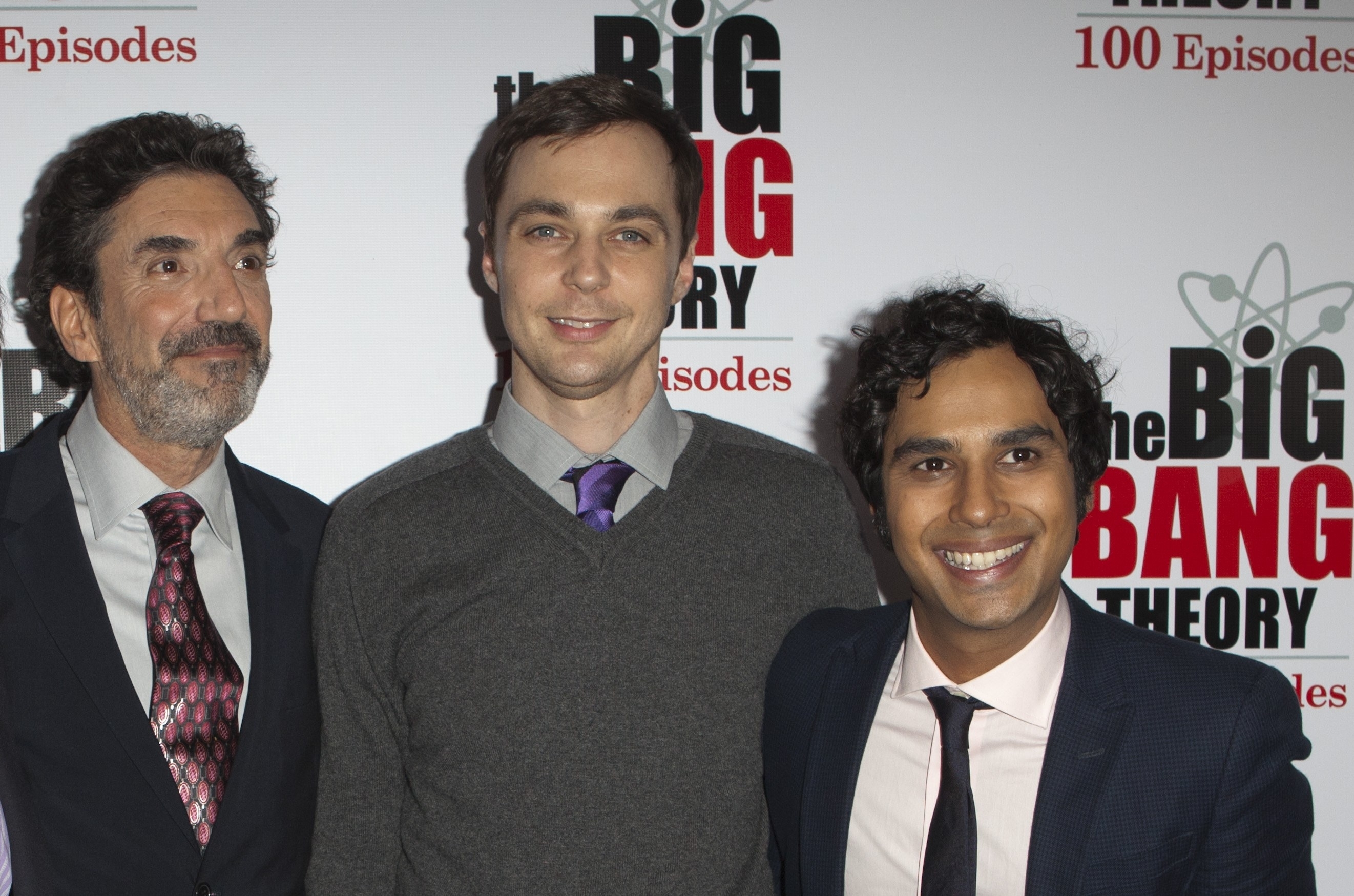 Chuck Lorre, Jim Parsons, and Kunal Nayyar at "The Big Bang Theory" 100th episode celebration. Chuck in a suit, Jim in a sweater and tie, Kunal in a suit and tie