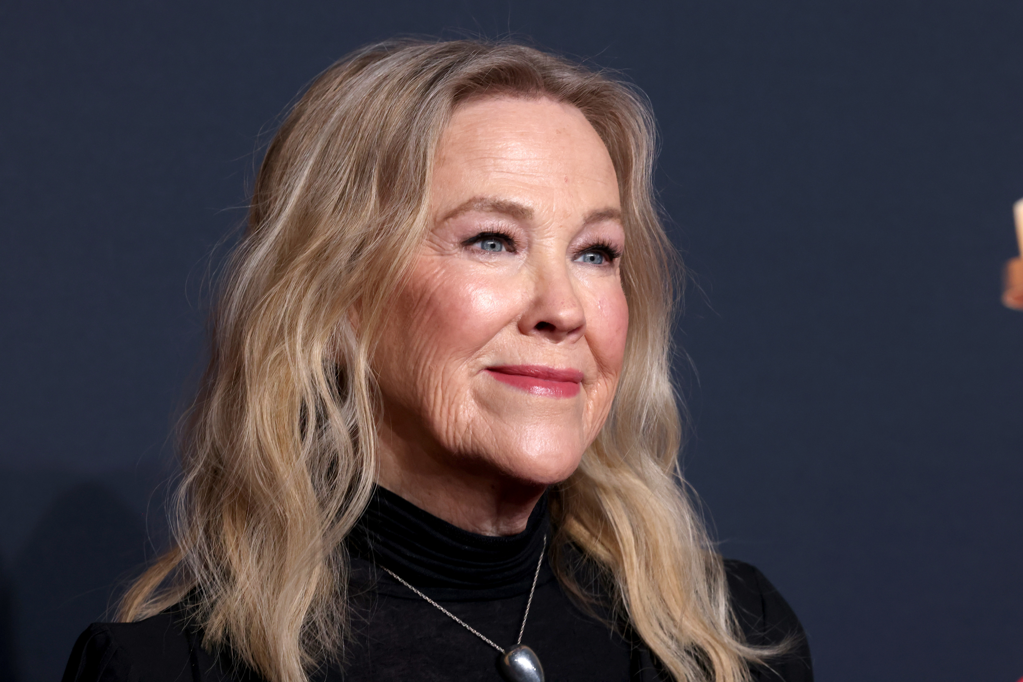 Catherine O'Hara, wearing formal wear, poses during a red carpet event