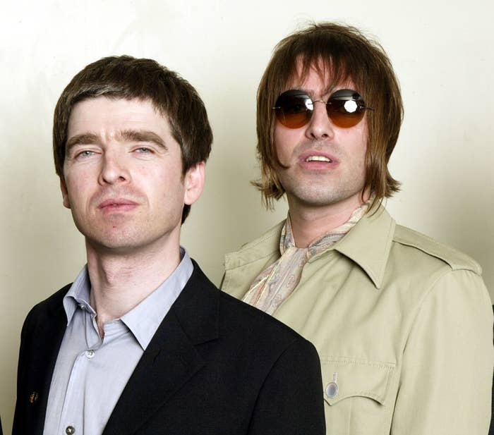 Noel Gallagher in a suit jacket and Liam Gallagher in sunglasses and a light jacket