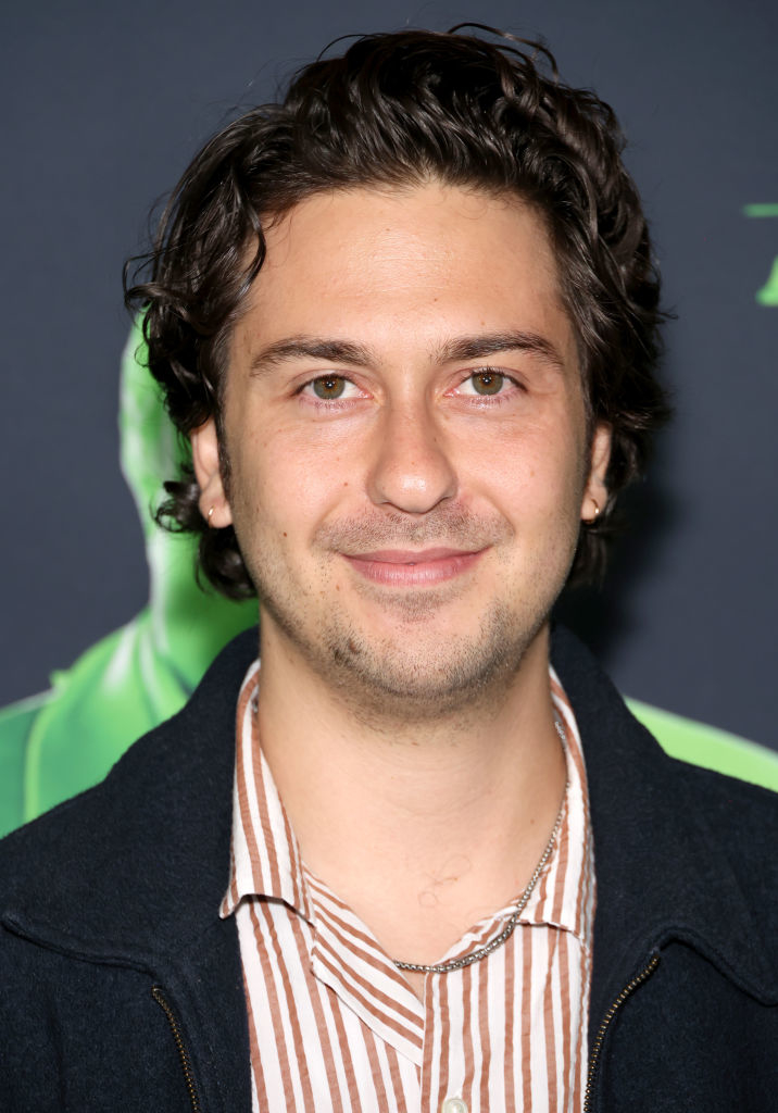 Nick Robinson at a media event, wearing a striped shirt under a dark jacket, smiling at the camera