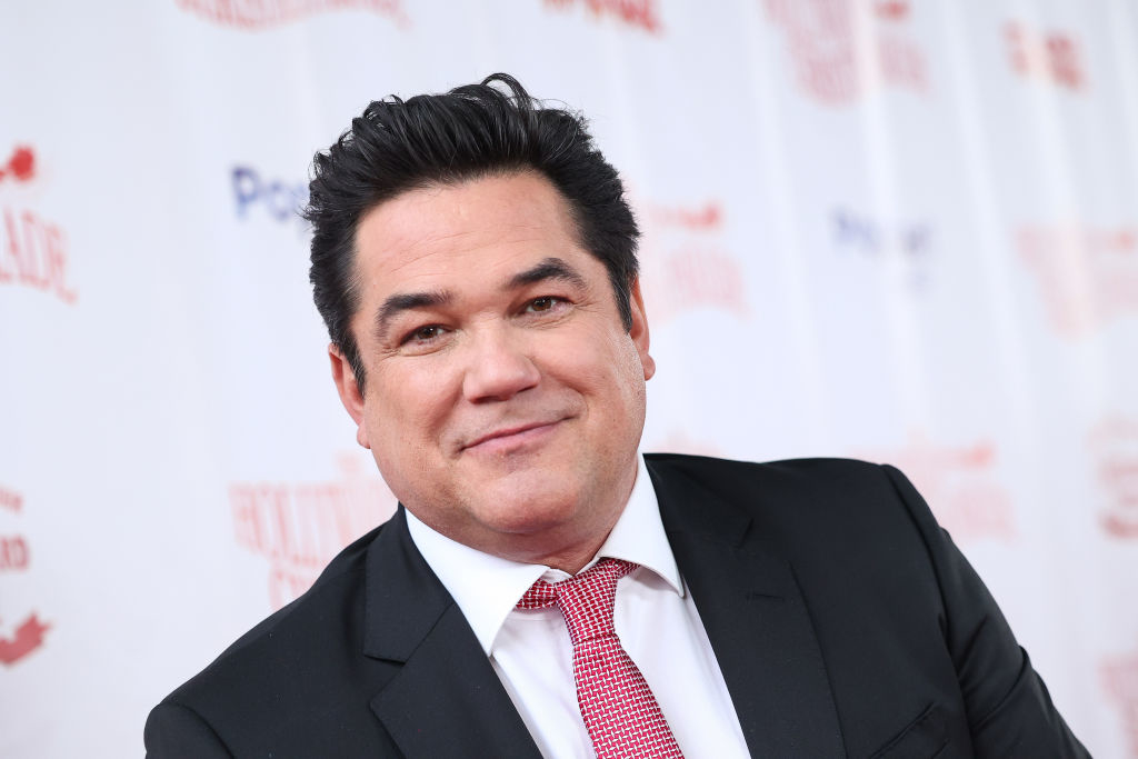 Dean Cain at a red carpet event wearing a suit, shirt, and a dotted tie