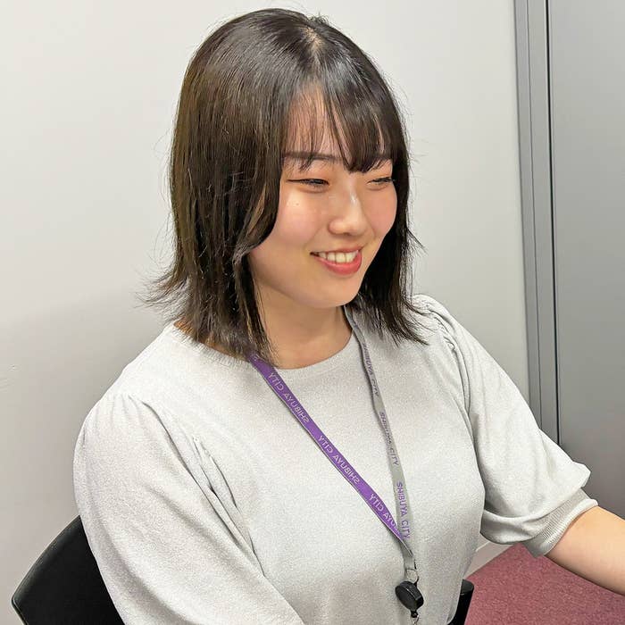 女性が微笑みながら座っています。