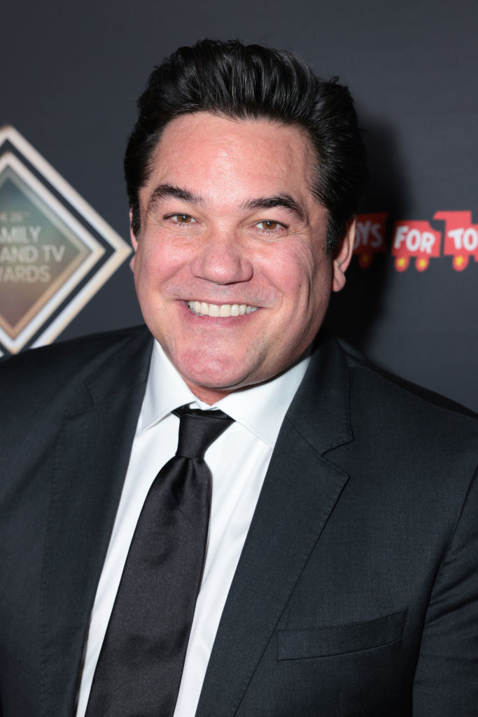 Dean Cain, smiling in a suit and tie, at a formal event