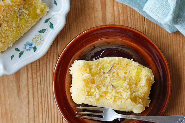 焼きたてのケーキが茶色の皿に盛られている。横には花の模様がある皿とナプキンが見える。