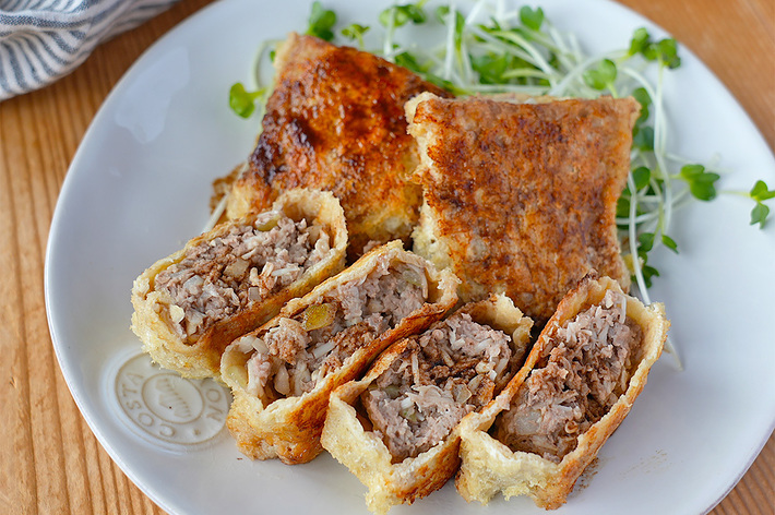 お皿に盛られたジュウシーな肉詰めの春巻きとカイワレ大根。