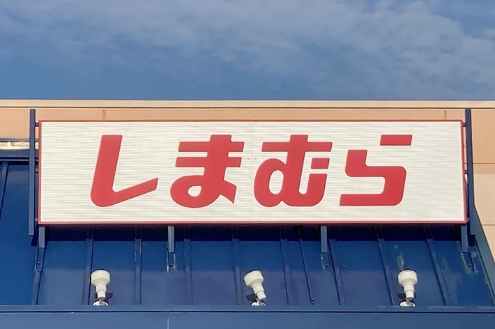 Storefront with red Japanese text on a sign above the entrance. Accessible parking sign is visible in the bottom right