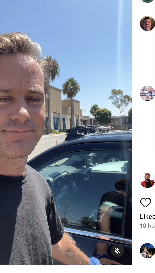 Armie Hammer takes a selfie outside with a parked car behind him