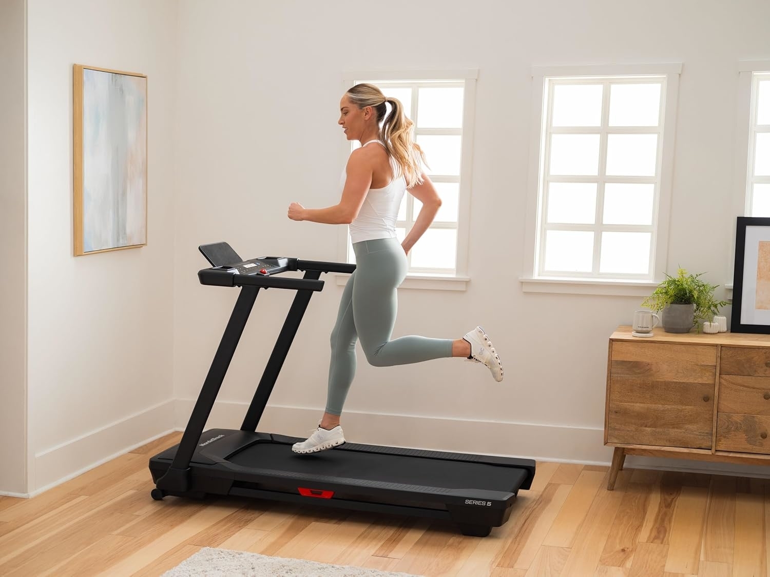 A model in workout attire runs on a treadmill