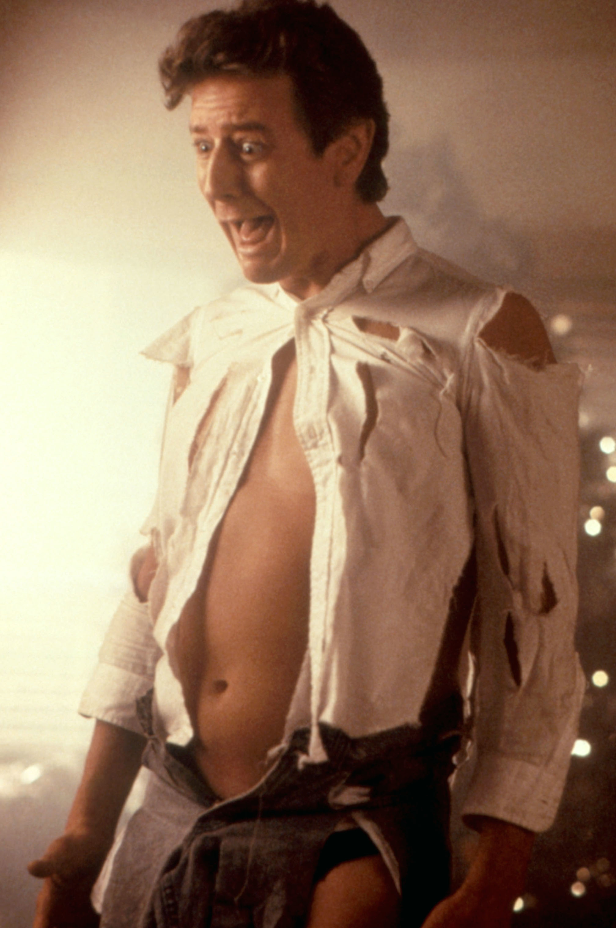 Man in a torn white shirt and open pants, looking surprised, in a scene suggesting humor