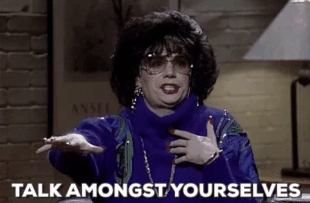 Mike Myers, dressed as Linda Richman, gestures with her hand while saying, &quot;Talk amongst yourselves.&quot;