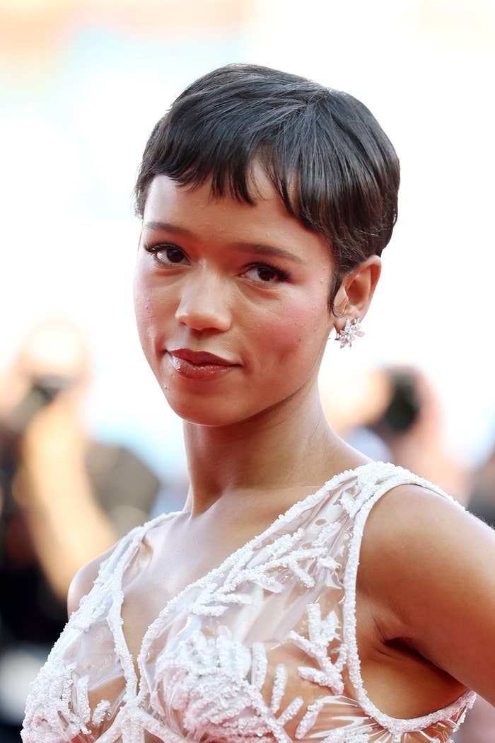 Taylor Russell poses on the red carpet in an elegant, sleeveless gown with intricate detailing