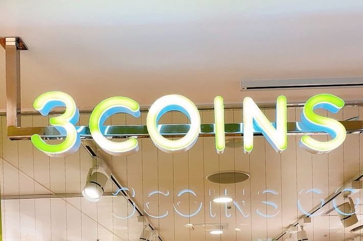 「3COINS」の店舗看板が映されている。