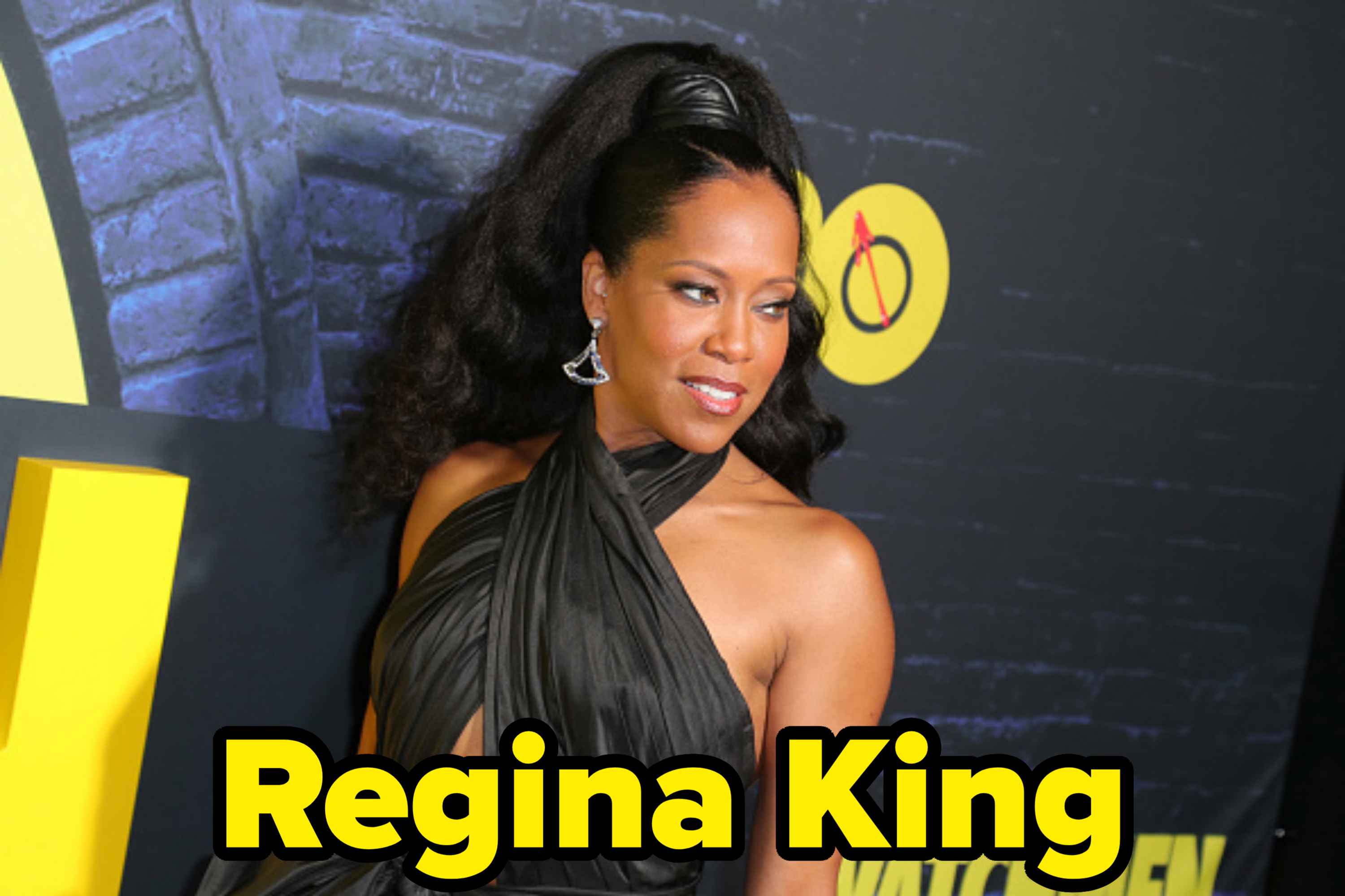 Regina King poses on the red carpet in an elegant, sleeveless black gown with a high neckline at a movie premiere
