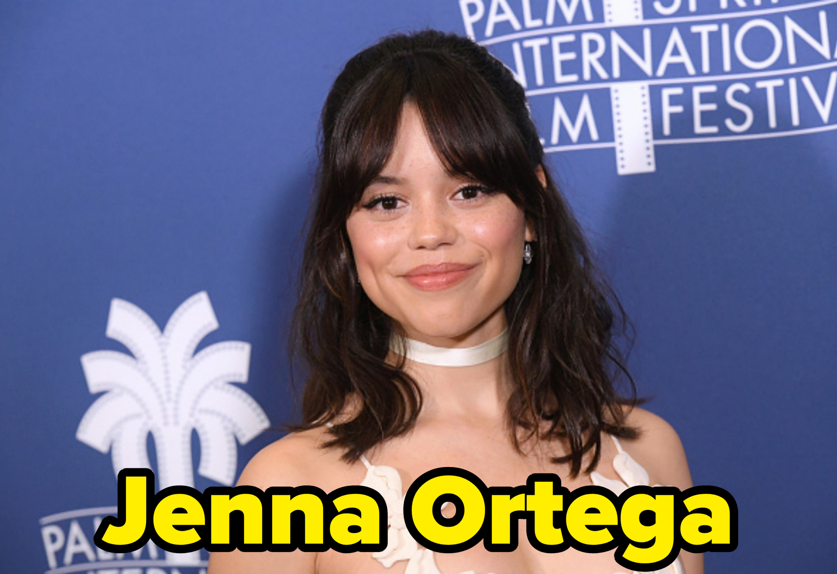 Jenna Ortega at the Palm Springs International Film Festival, wearing a strapless white dress with floral appliqué and a choker necklace