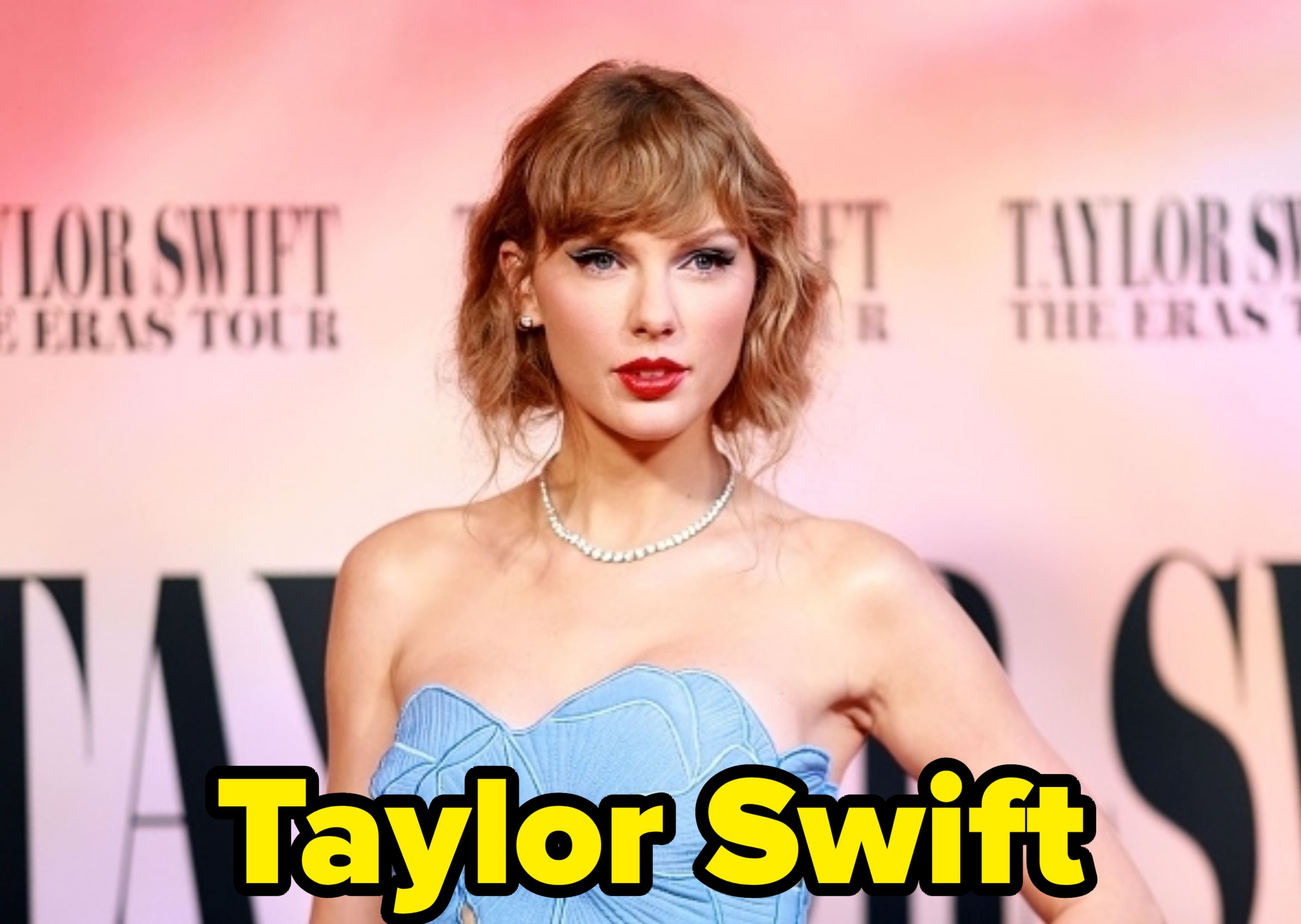 Taylor Swift stands on the red carpet at 'The Eras Tour' premiere, wearing an intricate strapless dress and a pearl necklace