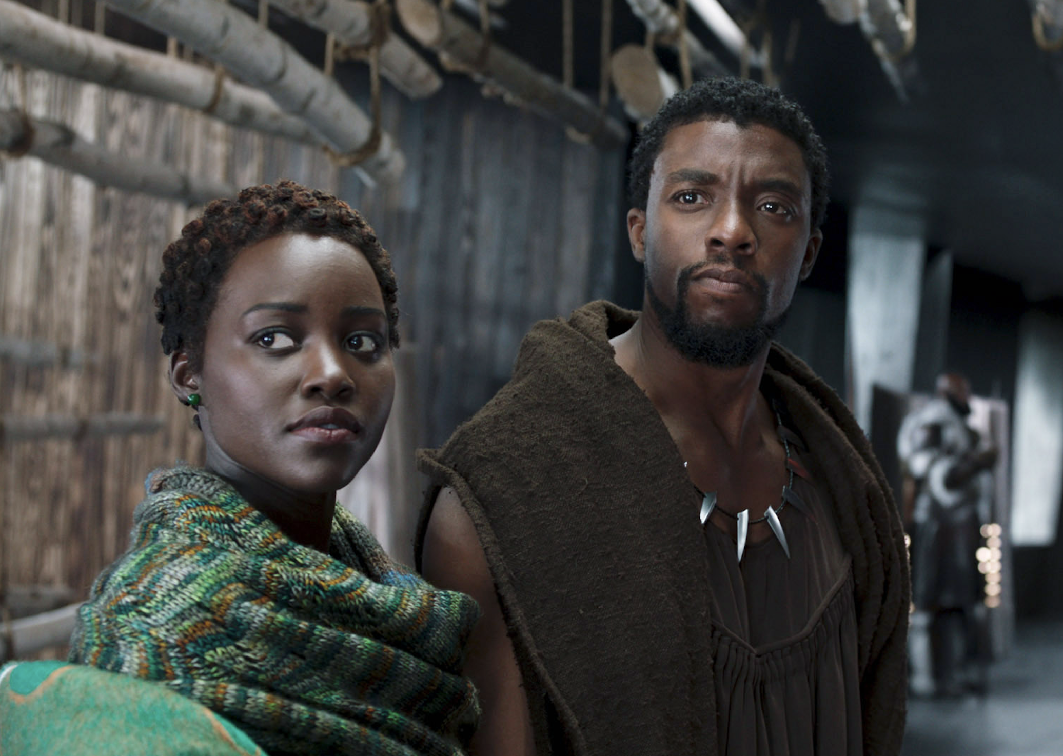 Lupita Nyong'o and Chadwick Boseman as Nakia and T'Challa in a scene from the movie "Black Panther," standing side by side, looking into the distance