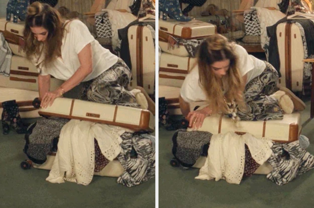 Annie Murphy in Schitt's Creek struggles to close an overpacked suitcase, sitting on it and pushing the contents down in a travel setting