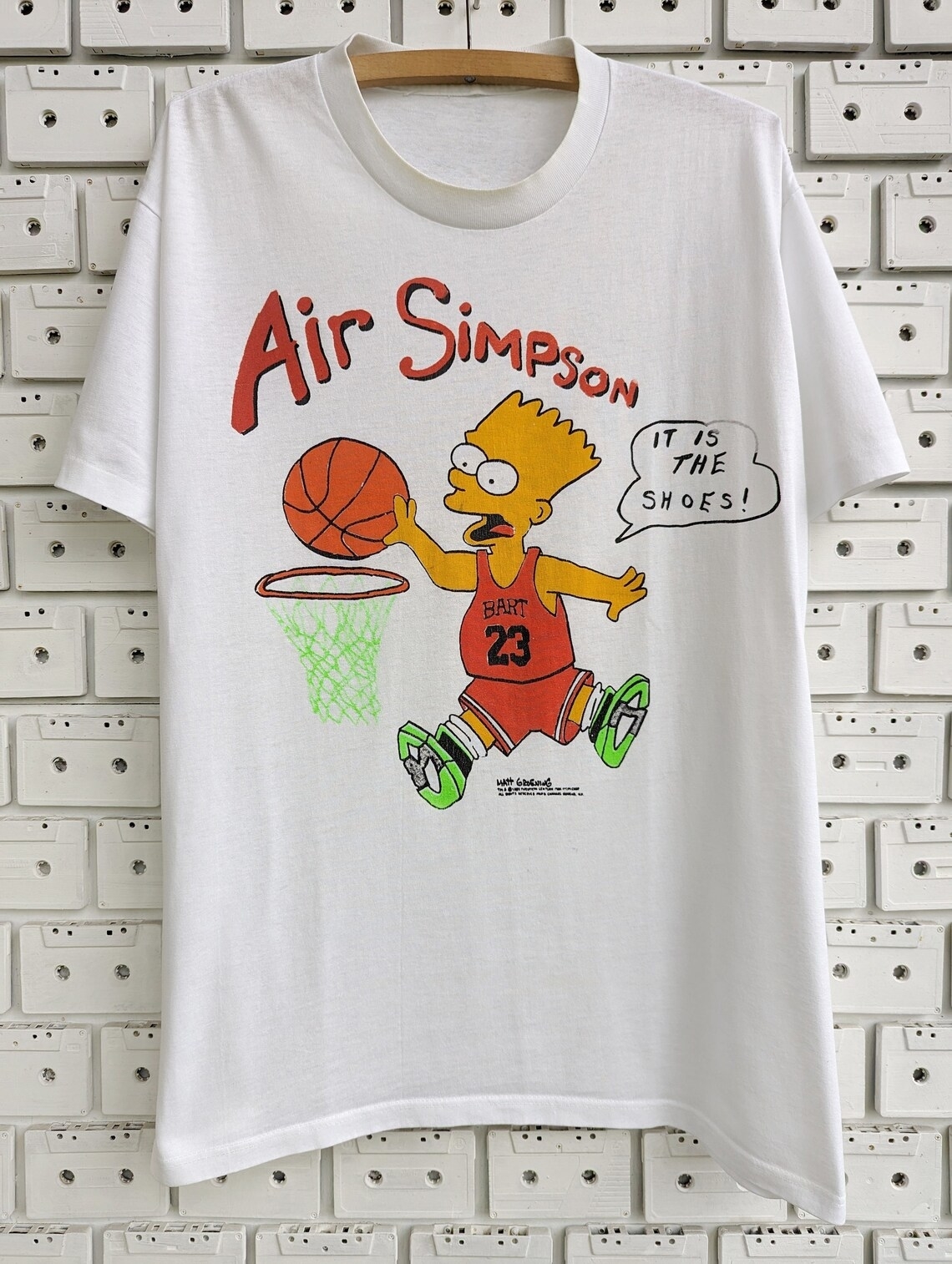 White T-shirt featuring Bart Simpson playing basketball with text "Air Simpson" and "It's the shoes!"