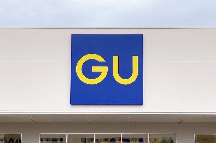 GU店舗の外観。青地に黄色い「GU」のロゴが中央上部に表示されている。店内には多くの衣類が陳列されているのが見える。
