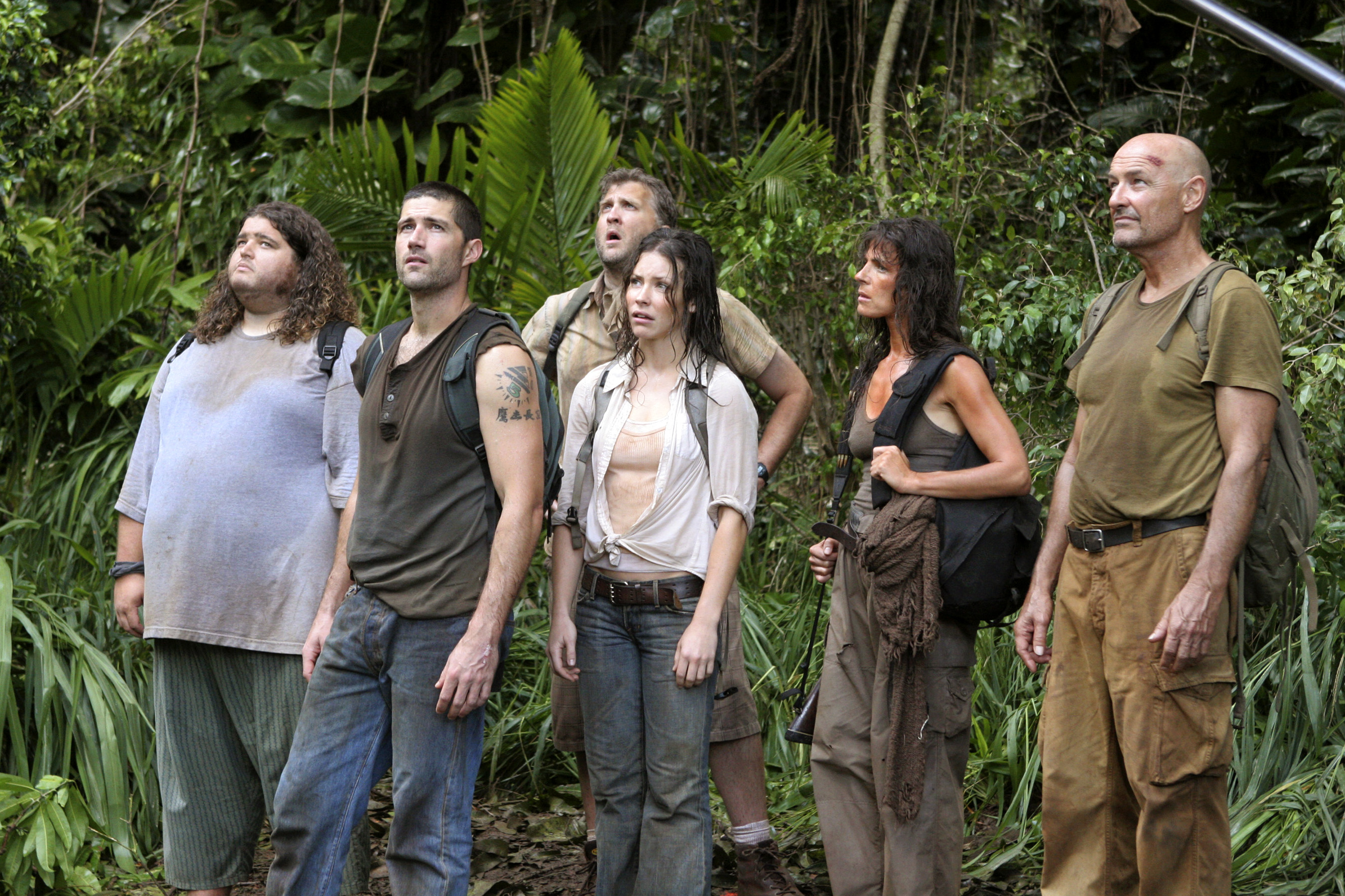Jorge Garcia, Matthew Fox, Dominic Monaghan, Evangeline Lilly, Maggie Grace, and Terry O'Quinn stand in a jungle wearing casual, adventure-style clothing