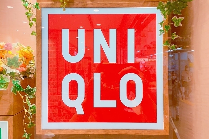 UNIQLO storefront sign framed with flowers and leaves, indicating the entrance to a UNIQLO store