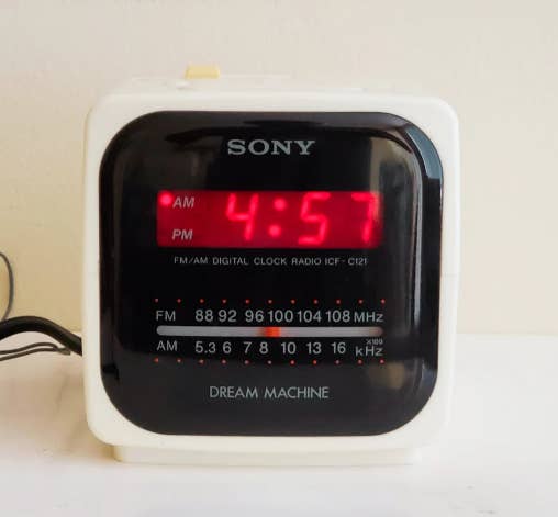 Digital alarm clock displaying 4:57 AM. Brand: Sony. FM/AM radio with frequency details, model ICF-C121, labeled "DREAM MACHINE"